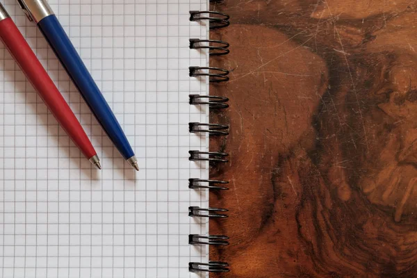 Dos plumas en un libro aislado sobre fondo de madera — Foto de Stock