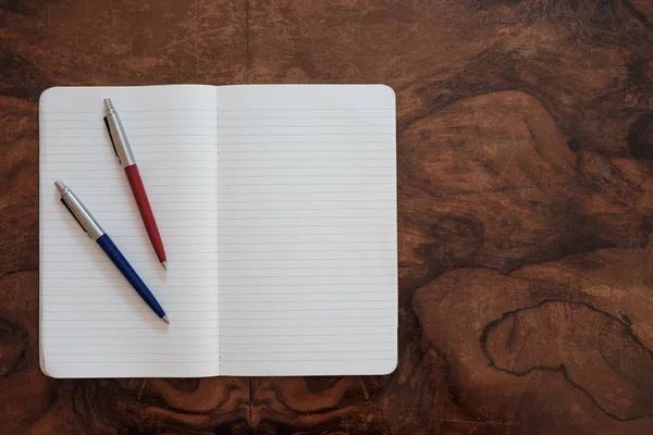 Kalemler üzerinde ahşap arka plan izole bir kopya kitap üzerine — Stok fotoğraf