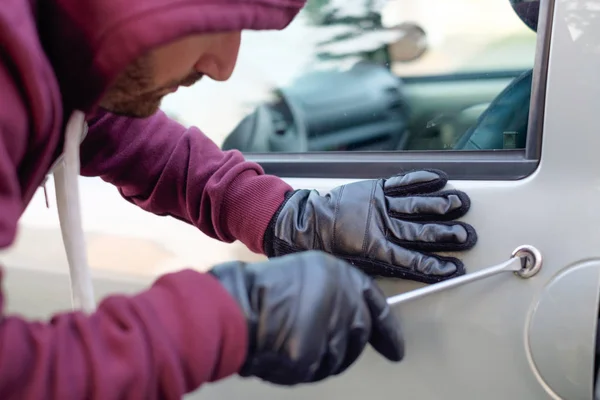 Ladrón encapuchado tratando de abrir una cerradura de puerta de coche —  Fotos de Stock