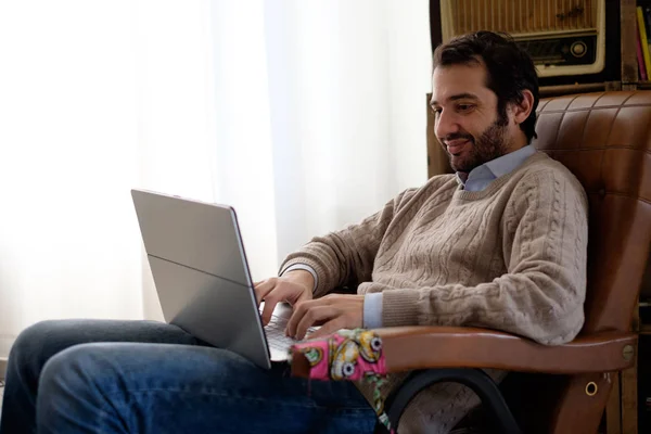 Uomo che lavora a casa con il suo computer portatile e connessione internet wi-fi — Foto Stock