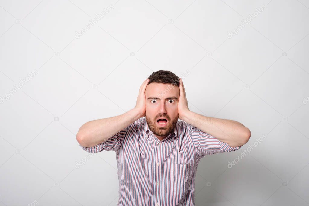 Man with hands on ears bothered annoyed