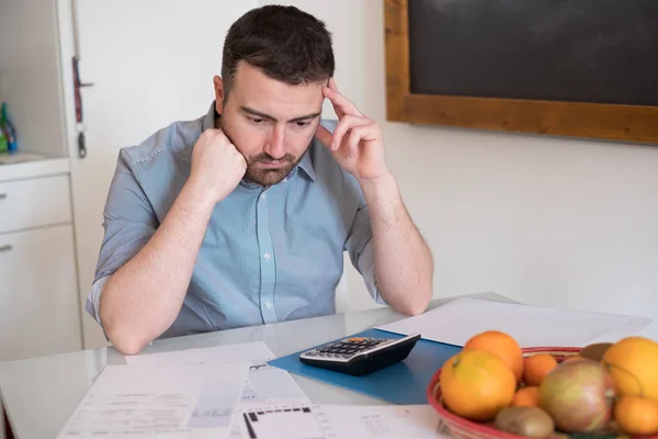 Frustrierter Mann berechnet Rechnungen und Steuern — Stockfoto
