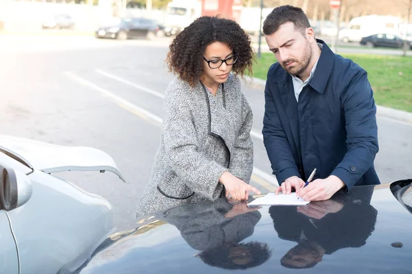 Hombre y mujer llenando un formulario de seguro de coche —  Fotos de Stock