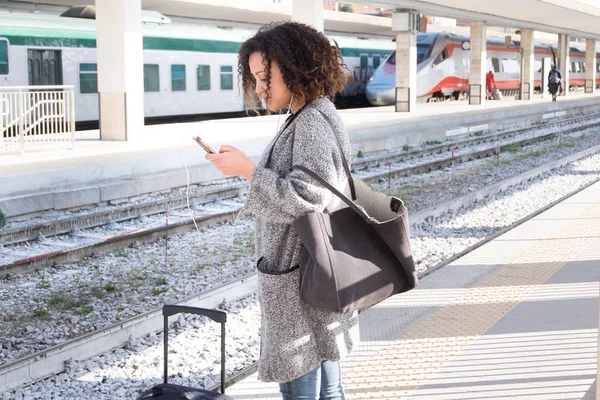Młoda kobieta czarny, czekając na pociąg — Zdjęcie stockowe