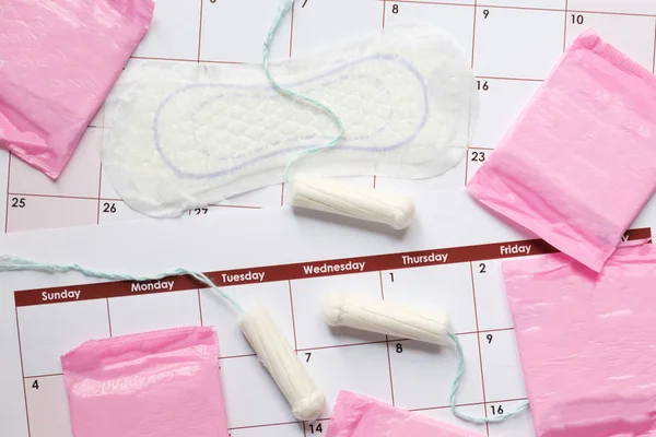 Tampões e almofadas menstruais em uma página de calendário — Fotografia de Stock