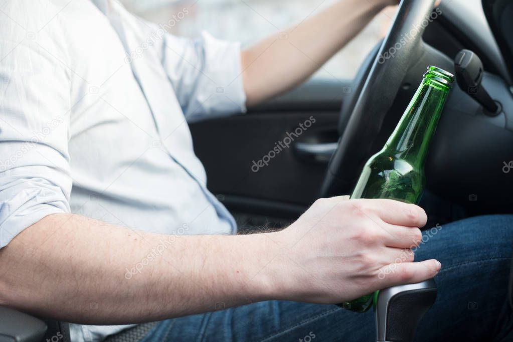 Man driving car and drinking alcohol