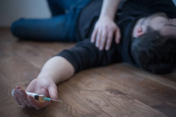 Hombre acostado en el suelo después de una sobredosis de drogas — Foto de Stock