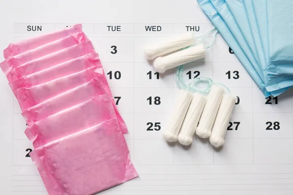 Menstruationstampons und -kissen auf einem Kalenderblatt — Stockfoto