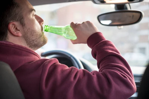 Hombre borracho conduciendo su coche y bebiendo — Foto de Stock