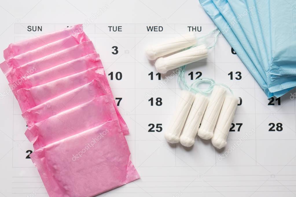 Menstrual tampons and pads on a calendar page
