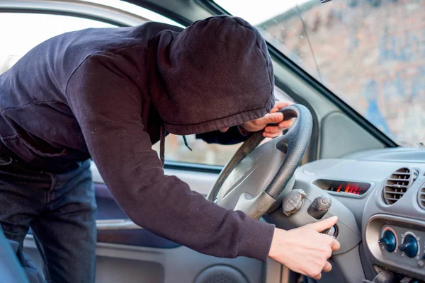 주차 된 자동차의 잠금을 선택 하려고 하는 도둑 — 스톡 사진