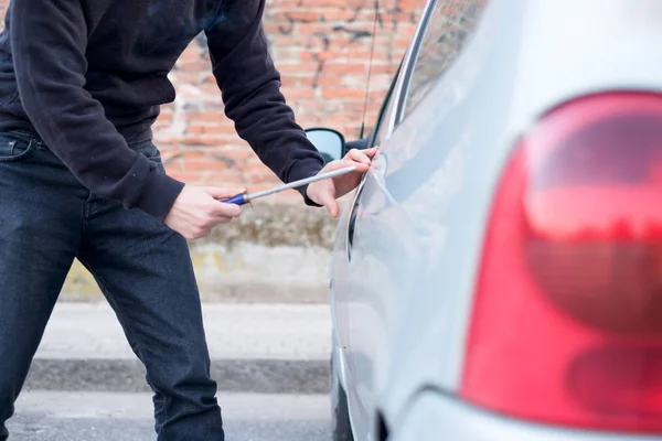 Ladrón tratando de abrir la cerradura del coche estacionado —  Fotos de Stock