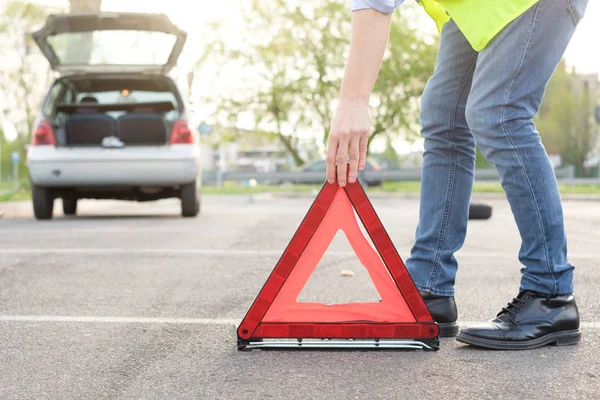 Homme plaçant un triangle rouge réfléchissant — Photo