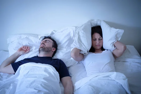 Cansada e irritada mulher de seu namorado roncando na cama — Fotografia de Stock