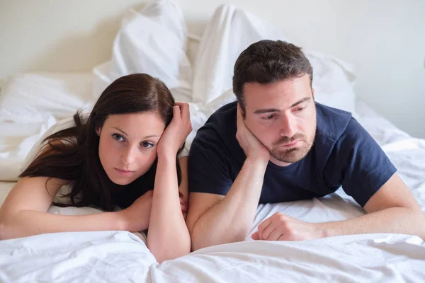Preocupado y aburrido amantes pareja después de una pelea acostado en la cama — Foto de Stock