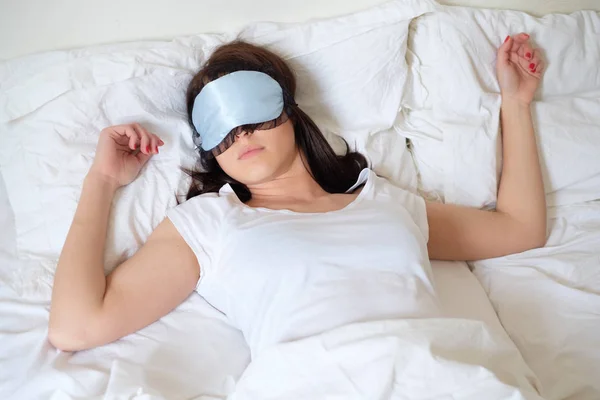 Mulher relaxada dormindo em sua cama usando máscara — Fotografia de Stock