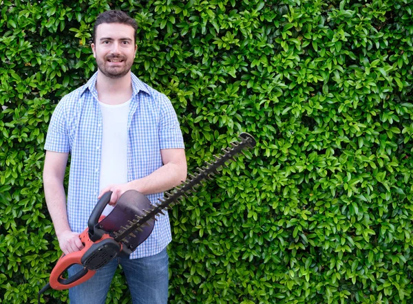 Hobbyist gardner met behulp van een hedge clipper in de tuin — Stockfoto