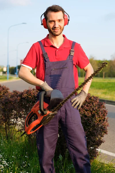 Jardinero profesional usando una recortadora de setos — Foto de Stock