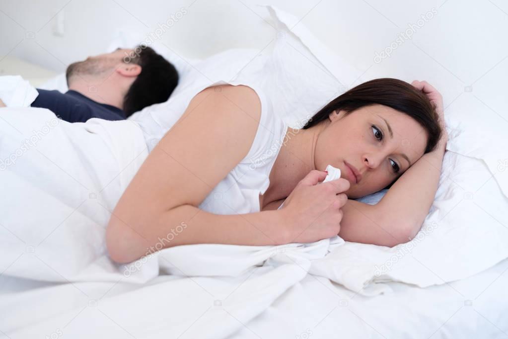Worried and bored lovers couple after a fight lying in bed