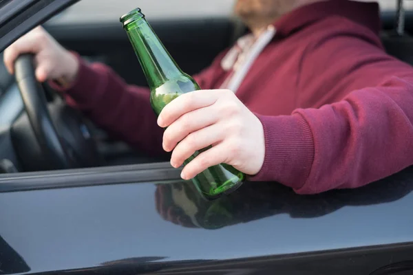 П'яний чоловік водить машину і п'є — стокове фото