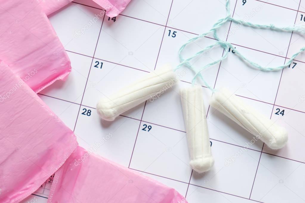 Menstrual tampons and pads on a calendar page