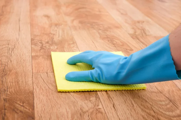 A hand cleaning a parquet floor — Stock Photo, Image