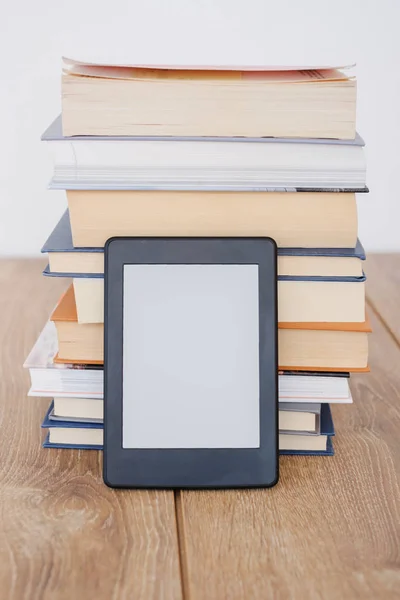 Lector de libros electrónicos en una pila de libros — Foto de Stock