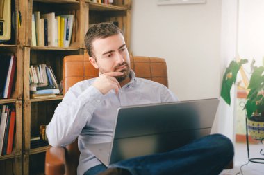 Onun laptop ve wi-fi internet connecti kullanarak evde çalışan adam