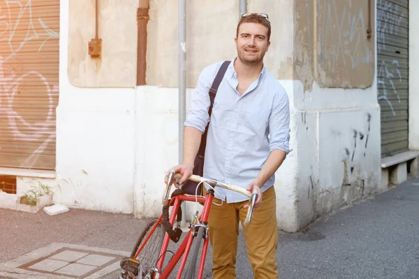 时尚男人的抱着他的自行车在城市街头 — 图库照片