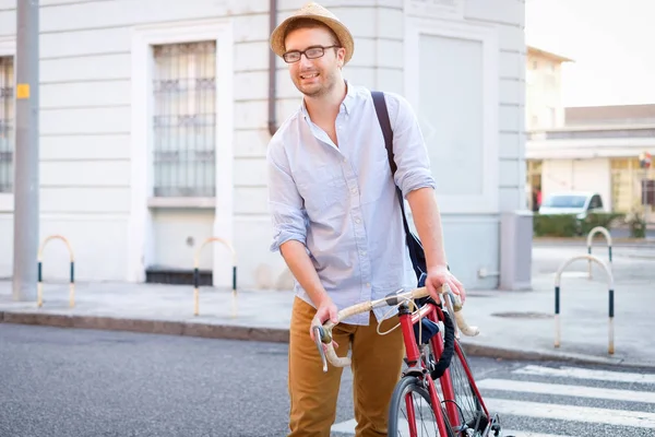 Hombre de moda sosteniendo su bicicleta en la calle de la ciudad — Foto de Stock