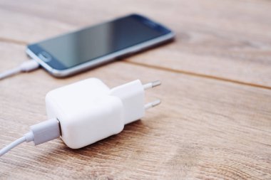 Hareket eden telefon ve şarj bir ofis masasında