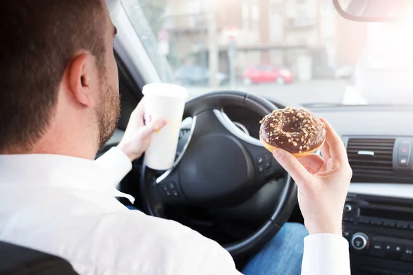 Muž s snídaně a řízení sedící v autě — Stock fotografie