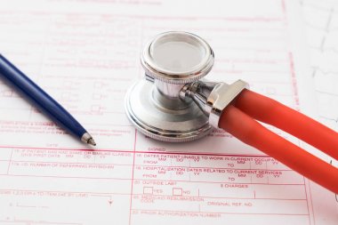 Sağlık sigortası talep formu, kalem ve stetoskop