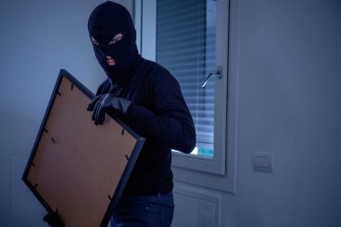 Hırsız çalmak bir boyama duvar ev içinde