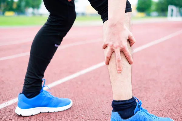 Atleta de corrida sentindo dor por causa da perna ferida — Fotografia de Stock