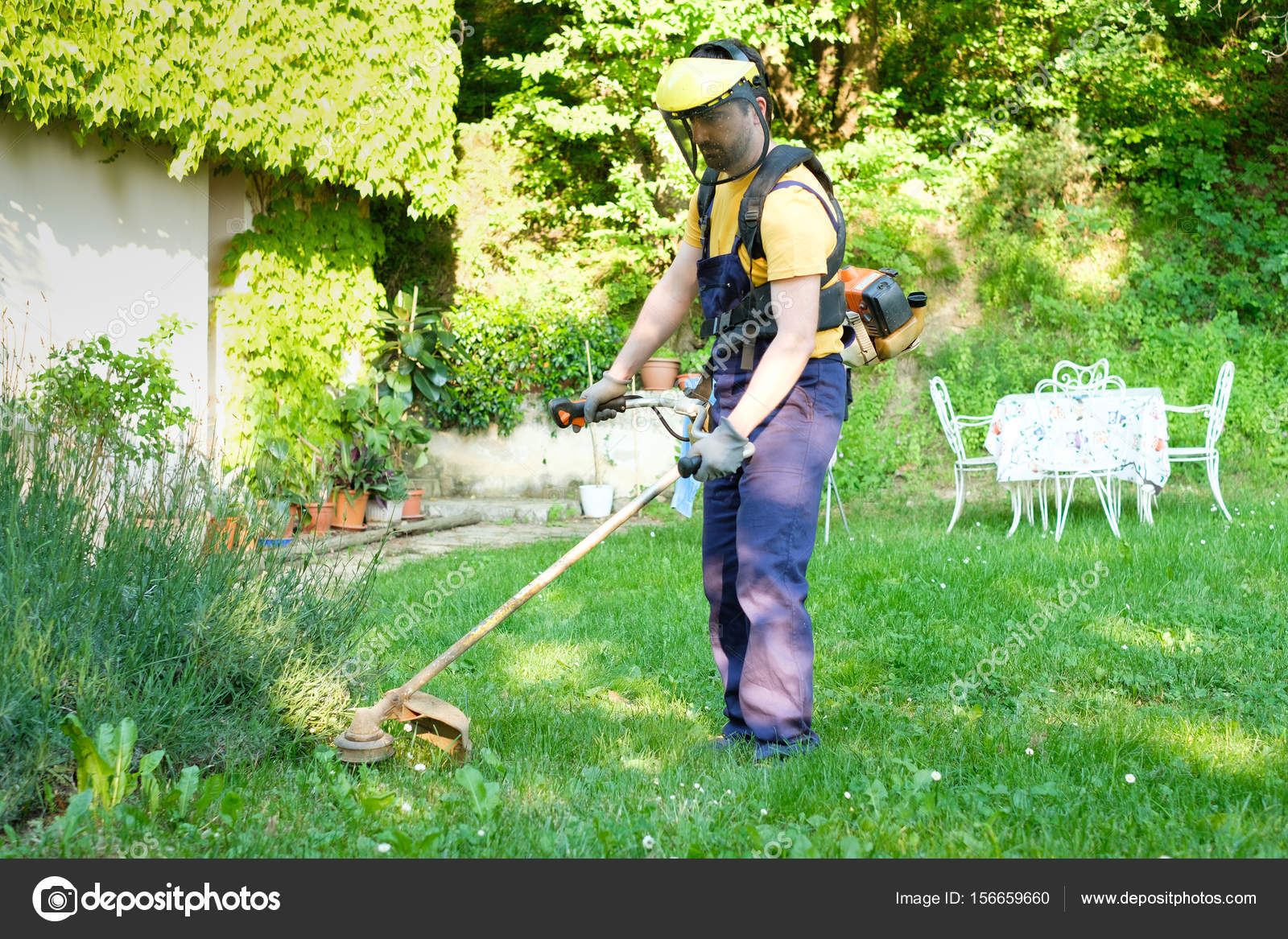 Professional Gardener Using An Edge Trimmer In Home Garden Stock Professional Gardener Using An Edge Trimmer In Home Garden Stock Photo