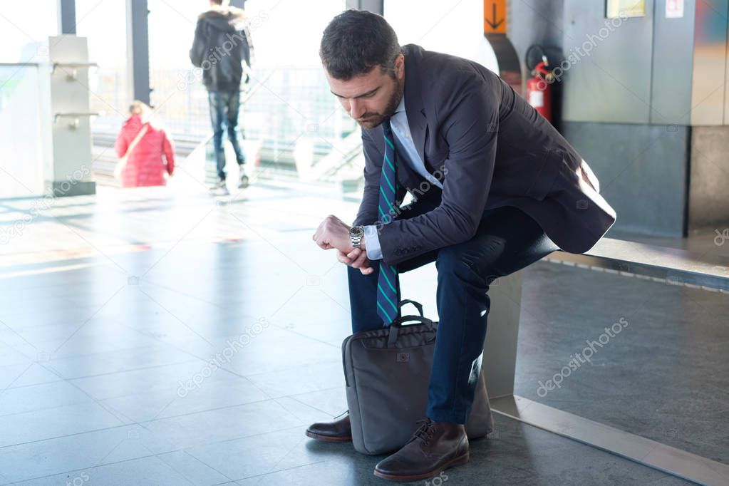 Tired businessman commuter is traveling and is waiting alone