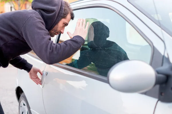 Ladrón mirando dentro de una ventana de coche listo para robar —  Fotos de Stock