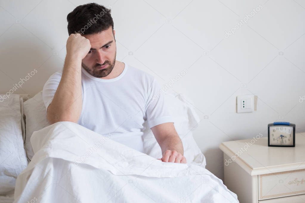 Sad and upset man waking up in the morning 