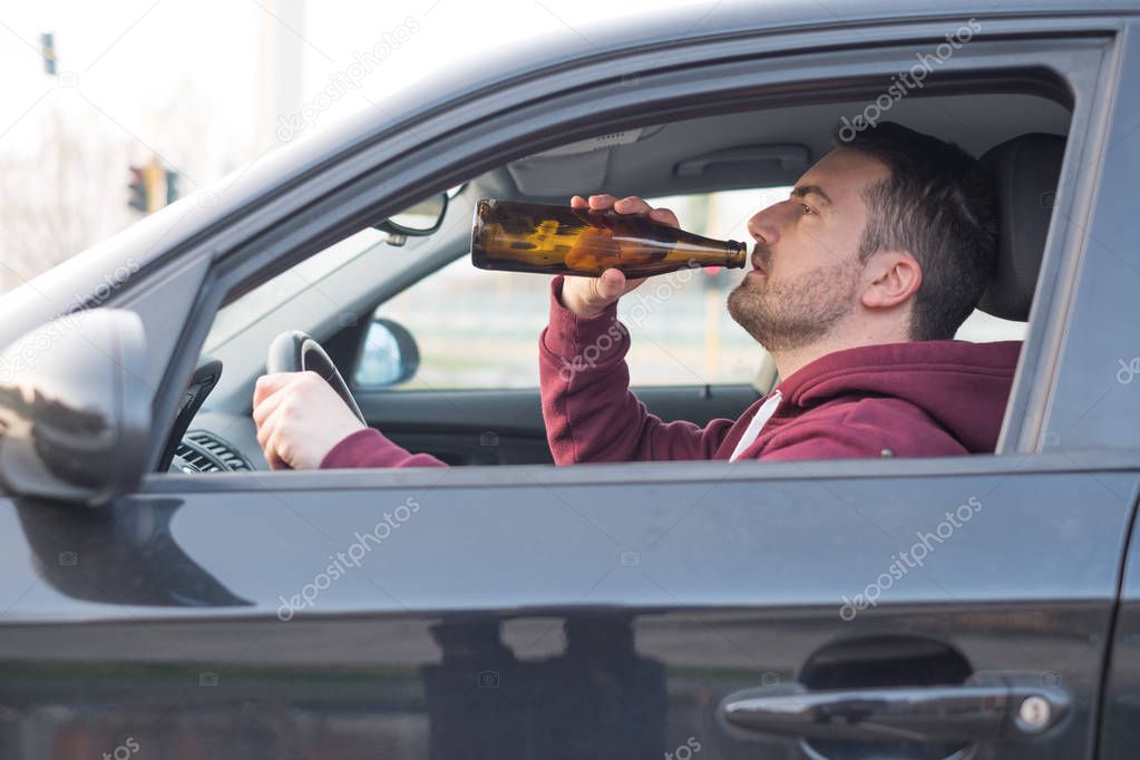 Drunk man driving his car and drinking