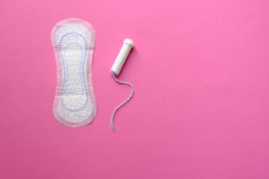 Adet tampon ve yastık pembe bir arka plan üzerinde