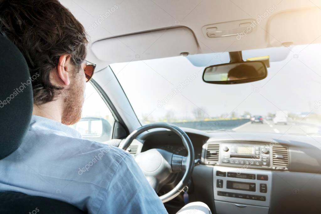 Man driving his car in in an highway