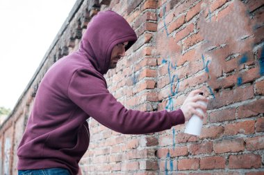 Kukuletalı tagger kentsel duvarlarda grafiti yazma