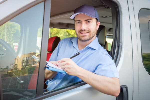 Portrait of confidence express courier on his delivery van
