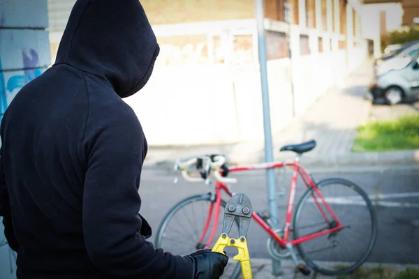 Ladrón robando una bicicleta estacionada en la calle de la ciudad — Foto de Stock