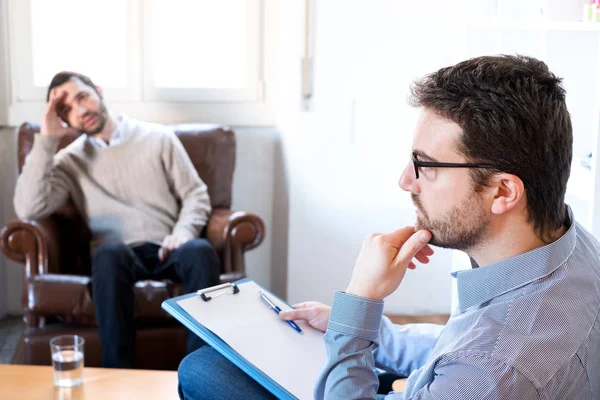 Psychologist taking notes during psychotherapy session — Stock Photo, Image