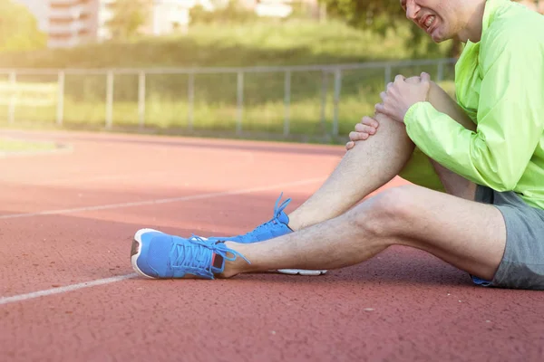 Atleta de corrida sentindo dor por causa da perna ferida — Fotografia de Stock