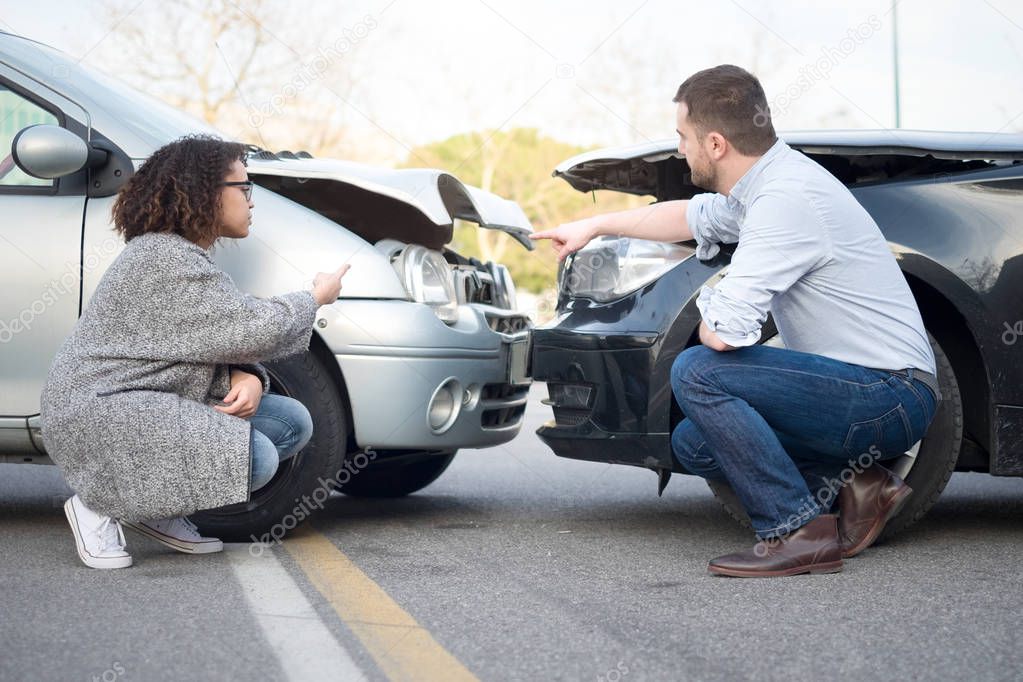 Man and woman arguing after a car crash
