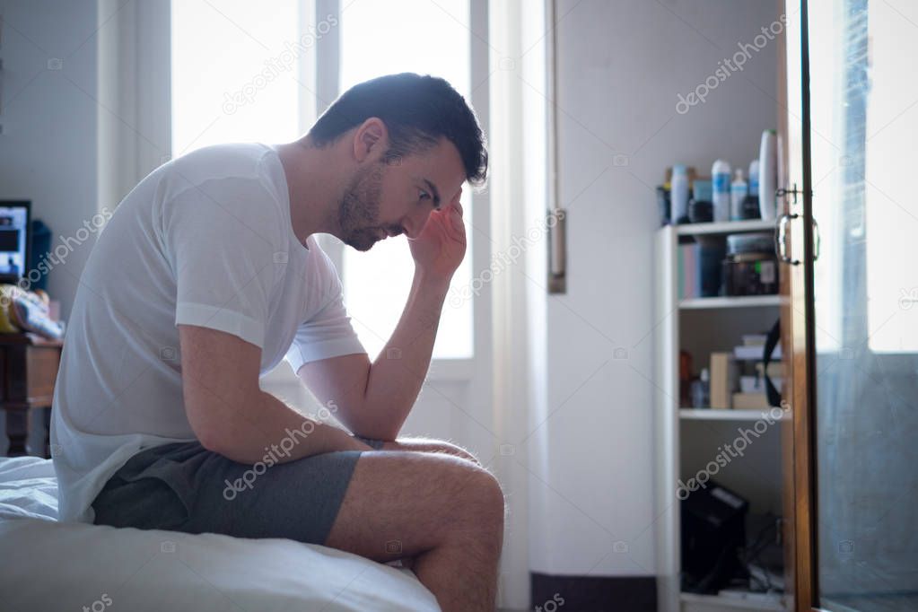 Sad and upset man waking up in the morning