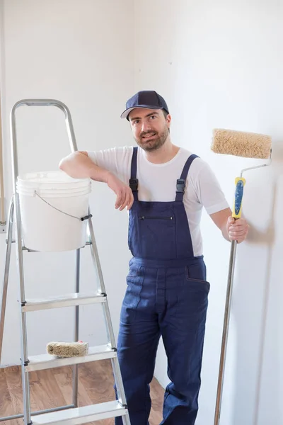 Man klaar om te schilderen een muur holding tekengereedschappen — Stockfoto